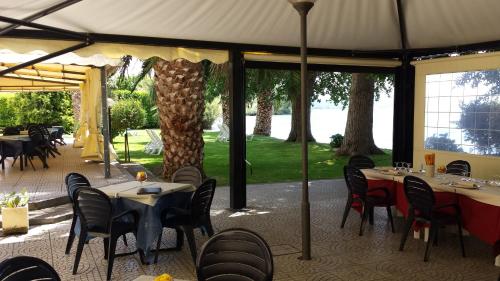 a restaurant with tables and chairs and a large tent at Hotel Eden Sul Lago in Bolsena