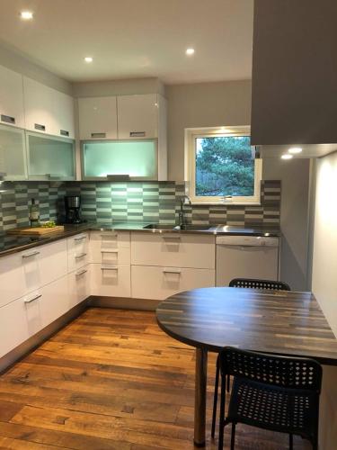 a kitchen with a wooden table and a wooden floor at Björsjödal Lake House's in Gothenburg