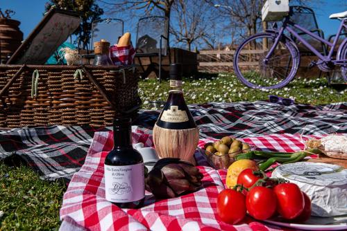 a picnic with a bottle of wine and a basket of food at LaChiusa Tuscany in Montefollonico