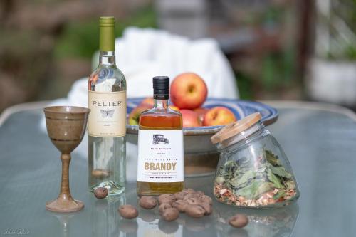 a table with two bottles of wine and a bowl of apples at Healing Hands in Merom Golan