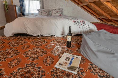 a bed with a bottle of wine and a magazine at Healing Hands in Merom Golan