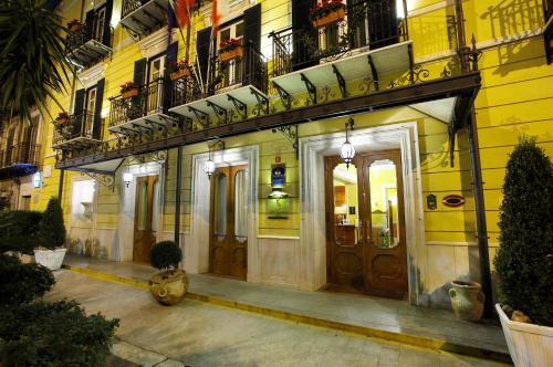 a yellow building with doors and balconies on it at Best Western Ai Cavalieri Hotel in Palermo