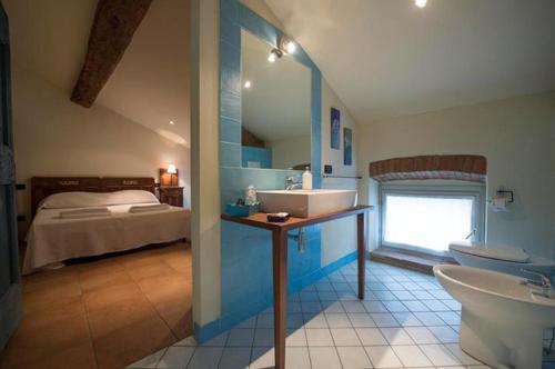 baño con lavabo y cama en Agriturismo Arte Contadina, en Fiorenzuola dʼArda