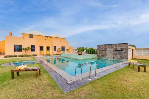 a swimming pool in the backyard of a house at Anand Bagh Resort & Spa by Ananta in Sālāsar