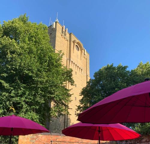 dois guarda-chuvas roxos sentados em frente a um edifício em Tower Hotel em Lincoln
