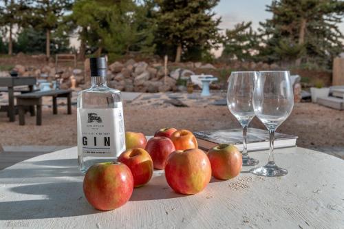 a bottle of wine and apples on a table with glasses at Ay La in El-Rom