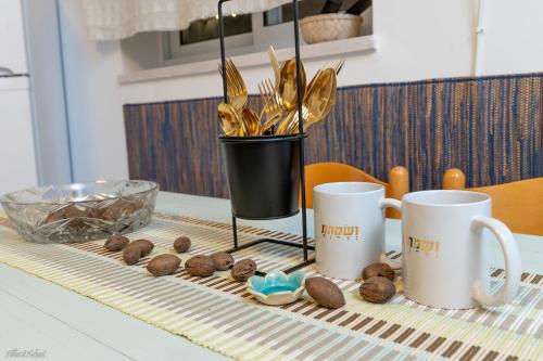 a table with two coffee cups and cookies on it at Ay La in El-Rom