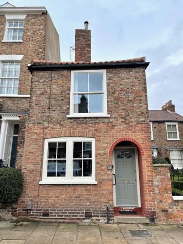 uma casa de tijolos com uma janela e uma porta em The Old Carriage House em York