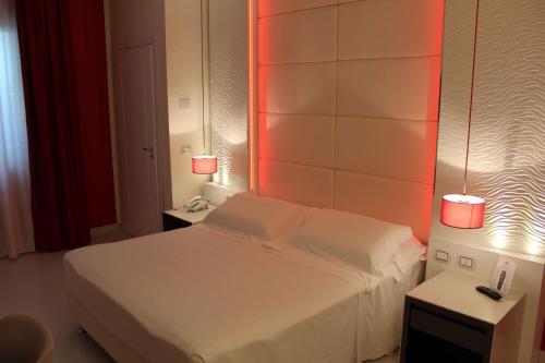 a bedroom with a white bed with red lights at Best Western Plus Hotel Perla Del Porto in Catanzaro Lido