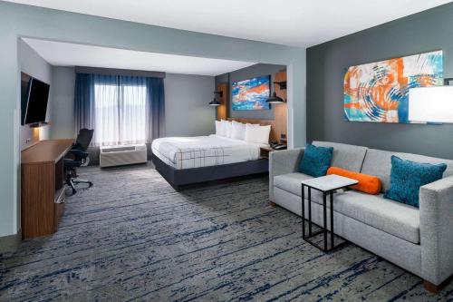 une chambre d'hôtel avec un lit et un canapé dans l'établissement La Quinta Inn & Suites by Wyndham-Albany GA, à Albany
