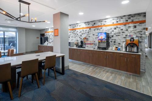 奥尔巴尼La Quinta Inn & Suites by Wyndham-Albany GA的有桌椅和酒吧的餐厅