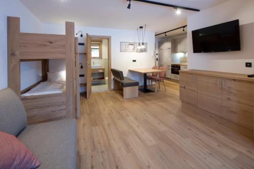 a bedroom with a bunk bed and a dining room at Appartement Haus Sonntal in Fieberbrunn