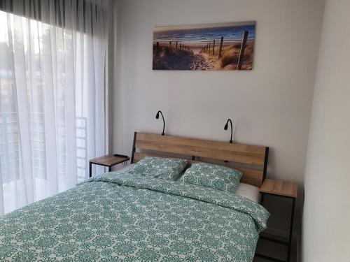 1 dormitorio con 1 cama con edredón verde en Aprum Apartments 10C en Pobierowo