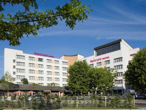 ein weißes Gebäude mit roten Buchstaben drauf. in der Unterkunft Mercure Hotel am Messeplatz Offenburg in Offenburg