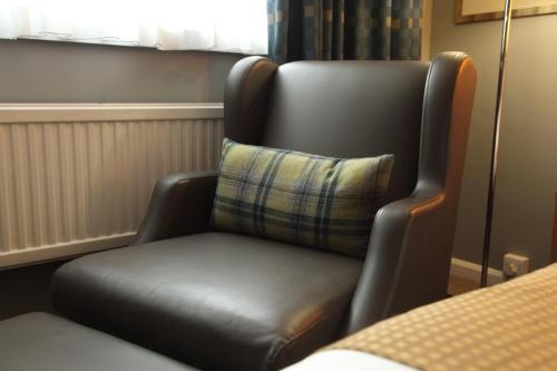a leather chair with a pillow in a room at Holiday Inn Oxford by IHG in Oxford
