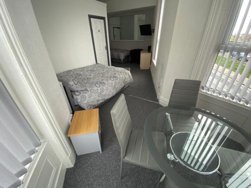 黑潭的住宿－The Honley hotel，小房间设有床和玻璃桌