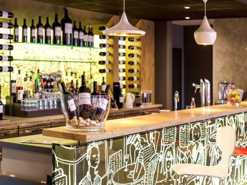 a bar with a bunch of bottles of wine at ibis Honfleur in Honfleur