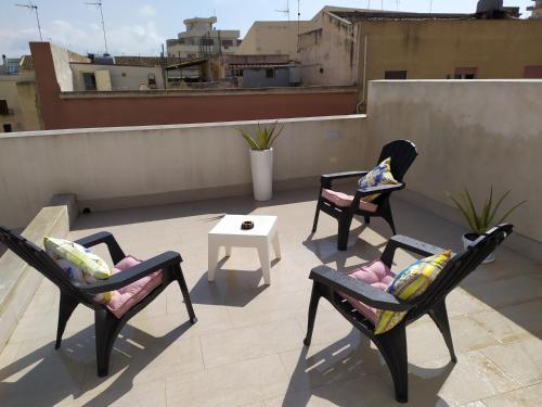 three chairs and a table on a roof at Slo Design House in Marsala
