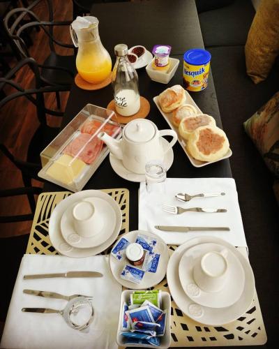 a table with plates and utensils and food on it at CASA DA GRAÇA in Ponta Delgada