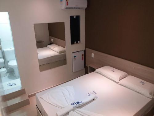 a small room with two beds and a mirror at Boca do Rio Hotel in Salvador
