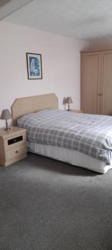 a bedroom with a bed and a night stand with two lamps at Overnight Stays Stockport in Stockport