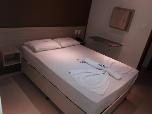 a bed with white sheets and towels on it at Boca do Rio Hotel in Salvador