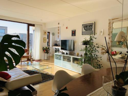 a living room with a glass table and a tv at ApartmentInCopenhagen Apartment 651 in Copenhagen