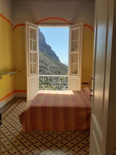 a bedroom with a bed and a view of a mountain at Casa Escuela in Valle Gran Rey