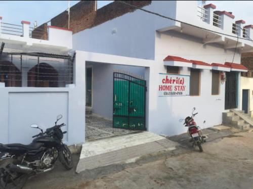 two motorcycles parked outside of a building with a green door at Vamoose Cherie Homestay in Khajurāho