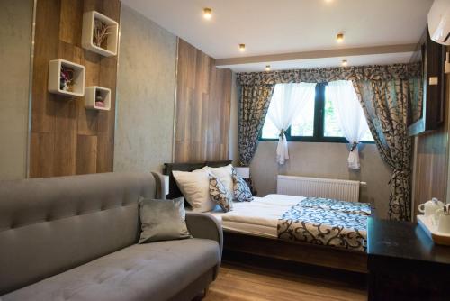 a bedroom with a bed and a couch and a window at Chata Wuja Toma in Szczyrk