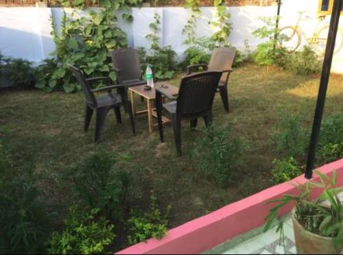 a group of chairs and a table in a yard at Vamoose Cherie Homestay in Khajurāho