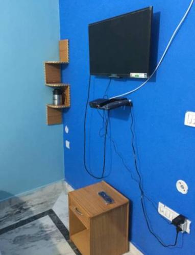 a blue wall with a computer monitor and a box at Vamoose Cherie Homestay in Khajurāho