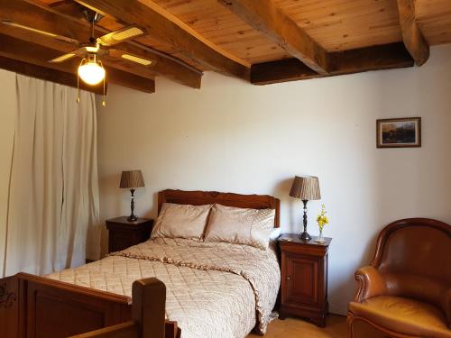 a bedroom with a bed and a chair at Bay Cottage Gite, Busserolles. in Busserolles