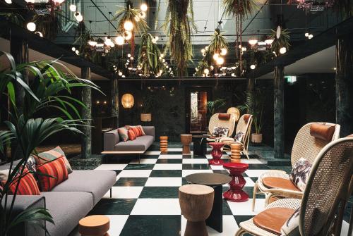 a lobby with couches and tables and potted plants at AMERON Zürich Bellerive au Lac in Zürich