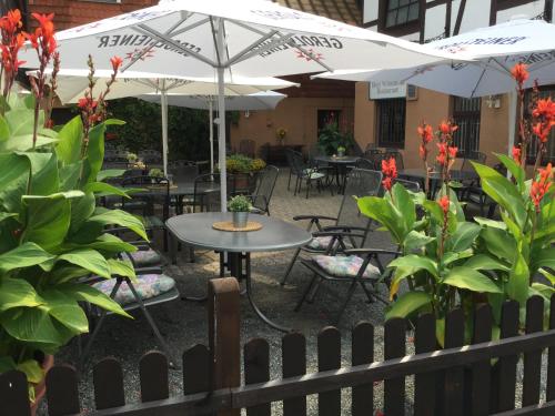 an outdoor patio with tables and chairs and umbrellas at Hotel-Restaurant Wilhelmsbad in Seesen