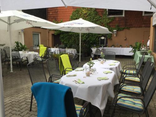 a group of tables and chairs with white umbrellas at Hotel-Restaurant Wilhelmsbad in Seesen