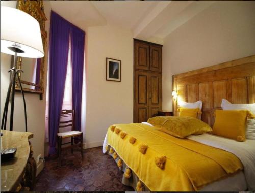 - une chambre avec un grand lit et des rideaux violets dans l'établissement Coté-Serein La Privilège de la Tour Madame, à Noyers-sur-Serein