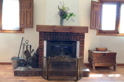 a living room with a brick fireplace and a table at Casa Rural Serafïn, Pet Friendly in Renera