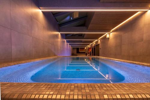 a swimming pool with blue water in a building at SPA Nida in Nida