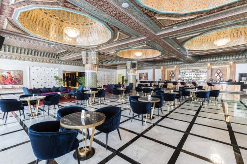 a restaurant with tables and chairs and a ceiling at Savoy Le Grand Hotel Marrakech in Marrakech