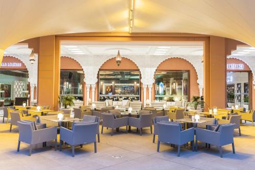 a restaurant with tables and chairs in a mall at Savoy Le Grand Hotel Marrakech in Marrakech
