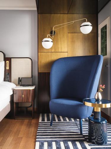 a blue chair and a table in a bedroom at AMERON Zürich Bellerive au Lac in Zürich
