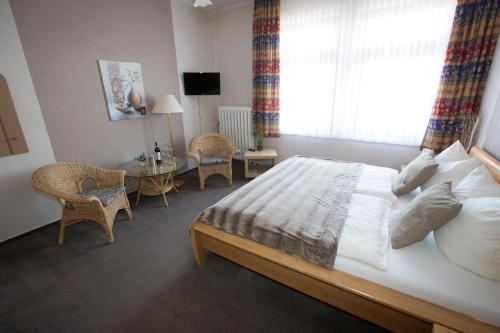 a bedroom with a bed and a table with chairs at Hotel-Restaurant Wilhelmsbad in Seesen