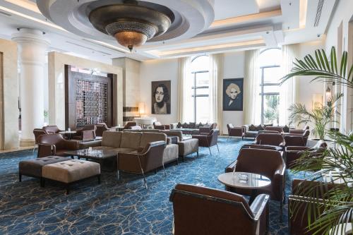 a hotel lobby with couches and tables and windows at Savoy Le Grand Hotel Marrakech in Marrakech