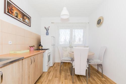a kitchen with a table and a white refrigerator at Krab in Rewal