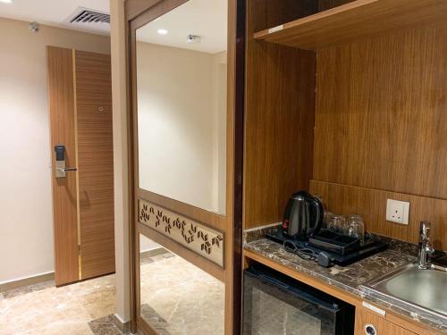 a kitchen with a sink and a microwave at Midan Hotel & Suites Al Aziziya in Makkah