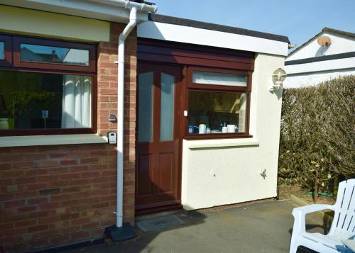a house with a brown door and a window at Teign Head Apartment in Newton Abbot