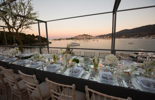 a long table with white plates and glasses on it at Xenia Poros Image Hotel in Poros