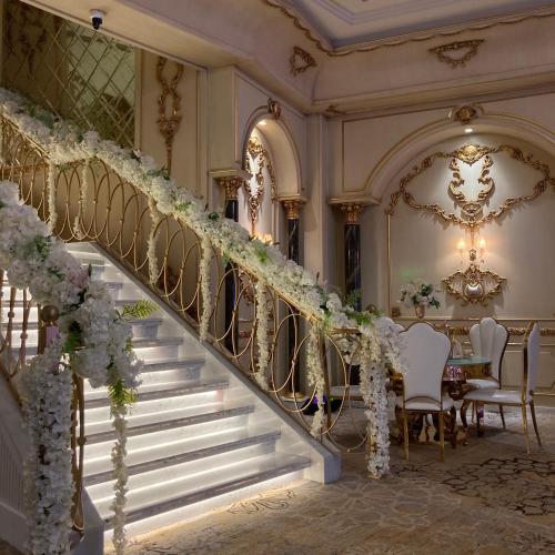 a staircase in a mansion with white flowers at Midan Hotel & Suites Al Aziziya in Makkah