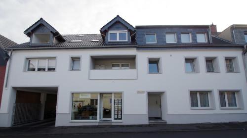 een wit huis met een zwart dak bij Studio-Apartment Sven in Bonn